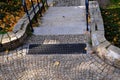 Stone park long staircase with short platforms. of paved granite paving blocks. short black metal railing interrupted several time Royalty Free Stock Photo