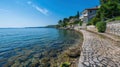 Stone Path Along a Clear Coastal Shore with a House on a Hillside Royalty Free Stock Photo