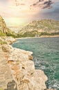 Stone path along the sea coast on sunset with rocky cliff on the side and blue sky near Nafplio cit Royalty Free Stock Photo