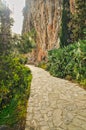 Stone path along the sea coast on sunset with rocky cliff on the side and blue sky near Nafplio cit Royalty Free Stock Photo