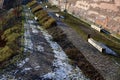 Stone path in the garden with terraced levels and stone nature paths with snow-covered lawns. garden bench in the shape of a beam Royalty Free Stock Photo