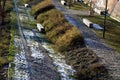 Stone path in the garden with terraced levels and stone nature paths with snow-covered lawns. garden bench in the shape of a beam Royalty Free Stock Photo