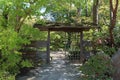 A stone path leading through a Japanese style arbor lined by shrubs and trees in Illinois Royalty Free Stock Photo