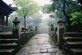 a stone path leads to a pagoda in the middle of a foggy day