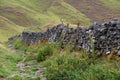 Stone path runs alongside a drystone wall. Peak district national park, Derbyshire.