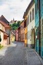 Stone paved old street with colored houses from Sighisoara fortresss, Transylvania Royalty Free Stock Photo