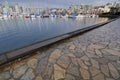 Stone paved seawall path by a marina Royalty Free Stock Photo