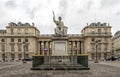 Stone paved square with scenic lightposts and an antique sculpture in front of National Assembly building, Paris