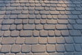 Stone pavement surface with square geometric pattern lit by warm natural sunlight creating textured outdoor background Royalty Free Stock Photo