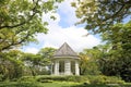 Stone pavilion in Singapore Botanic Gardens with trees and blue sky in Singapore