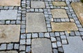 Stone paving with a geomentric pattern, a large rectangular tile lined around a smaller cobblestone paving cube, a pavement in a g