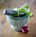 Stone pestle and mortar with mint and garlic