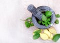 Stone pestle and mortar with mint leaves and ginger on a wooden table. top view. cold and flu remedy. Royalty Free Stock Photo