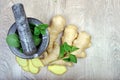 Stone pestle and mortar with mint leaves and ginger on a wooden table. top view. cold and flu remedy. copy spaces Royalty Free Stock Photo