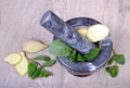 Stone pestle and mortar with mint leaves and ginger on a wooden table. top view. cold and flu remedy. copy spaces Royalty Free Stock Photo