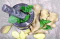 Stone pestle and mortar with mint leaves and ginger on a wooden table. top view. cold and flu remedy. Royalty Free Stock Photo