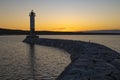 Stone pier and old Vuohensalo lighthouse in April sunset. Motornaya bay, Ladoga lake Royalty Free Stock Photo