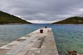 Stone pier with ruined bollard.Completely rusted dilapidated iron mooring bollard in middle of stone pier