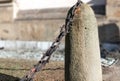 Stone pillar, chain with rust, on an isolated background, selective focus