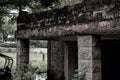 Stone pillar from a scary looking wooden house at a park giving an eerie vibes around it in the midday