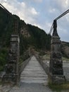 Old wooden suspension bridge over mountain river