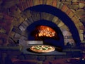 Stone pizza oven and pepperoni pizza close up Royalty Free Stock Photo