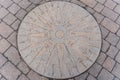 A stone plaque of the compass points on the pavement in the town square of Amble, Northumberland, UK
