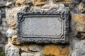 A stone plaque on a stone wall with yellow lichen on it Royalty Free Stock Photo