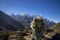 Stone, prayer flags, a valley and a mountain range in the Himalayan area in Nepal Royalty Free Stock Photo