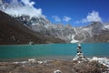 Stone pyramid next to sacred Gokyo lake with view of Renjo La pass. Hiking in Nepal