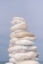 Stone pyramid on sky beach Zen rock in concept of balance and harmony Royalty Free Stock Photo