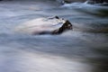 Stone in a river with fast moving water around Royalty Free Stock Photo