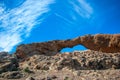 Stone rock with weathered hole on blue sky background Royalty Free Stock Photo