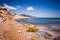 Stone and rocks beach with nobody close to the mountain and a scenic blue sky Royalty Free Stock Photo