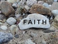 Stone between rocks with written word faith on rock background Royalty Free Stock Photo