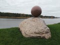 Stone sculpture ball sphere nex to river