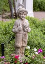 Stone sculpture of a boy holding flowers in a garden at the Hill and Gilstrap Law Firm in Arlington, Texas.