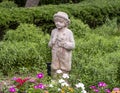 Stone sculpture of a boy holding flowers in a garden at the Hill and Gilstrap Law Firm in Arlington, Texas.