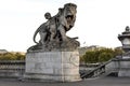 A stone sculpture of a nymph and lion at the entry to the Alexander III bridge and access to Seine river, Paris