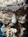 Stone sculpture of old mans face with tongue sticking out