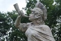 Stone sculpture of a Triton, blowing on his conch shell trumpet