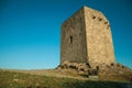 Stone square tower over rocky hill on sunset Royalty Free Stock Photo