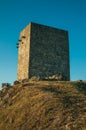 Stone square tower over rocky hill on sunset Royalty Free Stock Photo