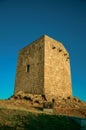 Stone square tower over rocky hill on sunset Royalty Free Stock Photo