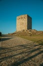 Stone square tower over rocky hill on sunset Royalty Free Stock Photo