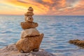 Stone stacking on the coast at sunset