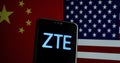 ZTE logo on a smartphone and flags of China and US on the blurred background. ZTE is Royalty Free Stock Photo