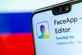 FaceApp logo on the screen of smartphone with the flag of Russia at the blurred background behind it. Conceptual editorial illustr