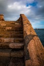 Stone staircase and lighthouse of the port of almeria at sunset