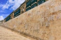 Stone stairs and wall with metal rail in the historic center of Valletta, Malta. Blue sky and traditional Maltese buildings backgr Royalty Free Stock Photo